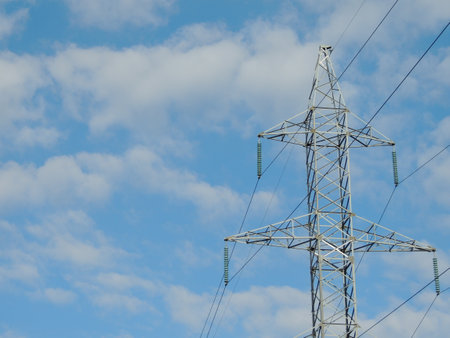 white iron power transmission line tower with wires stretching into the distance against a beautiful...