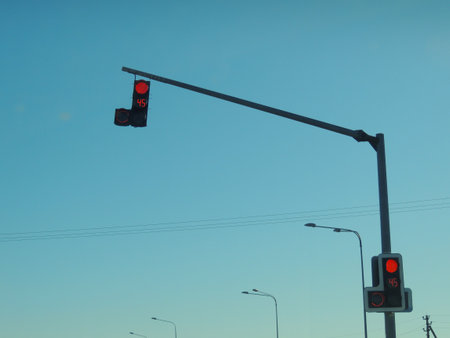 overhead traffic light for cars and pedestrians with red signal color on sky background, number 45 on traffic light board with working prohibitory signalの写真素材