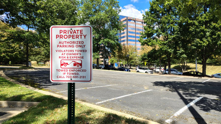 Chantilly, Virginia, USA - 10.22025: A sign informing that this parking lot is reserved for authorized persons only, with a residential building and cars in the backgroundのeditorial素材