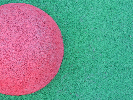 Pink circle on a green background as a geometric colorful abstraction, fragment of playground covering with colorful elements and abstract structure, rubber crumb material in sportの写真素材
