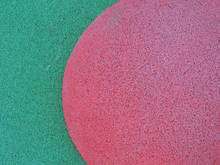 half a pink circle on a green background as a textured abstract background made of grainy dotted material in light tonesの写真素材
