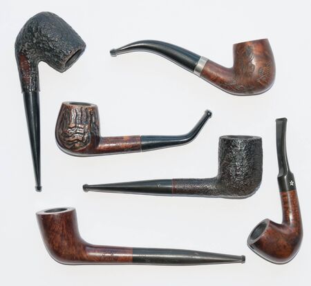 six old wooden smoking pipes close-up on whiteの写真素材