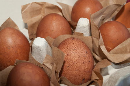 Easter eggs wrapped in craft paper inside the carton box close-up
