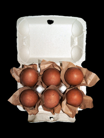 Easter eggs wrapped in craft paper inside the carton box isolated on a black background top viewの写真素材