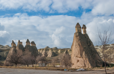 Beautiful historical landscape from Cappadocia with earthen pyramids under the cloudy winter sky in Goremeの写真素材