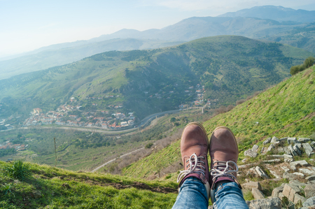Girls legs in jeans and purple boots with Ancient Greek amphitheater at Pergamon in the territory of the modern city of Bergama in Turkey on backgroundの写真素材
