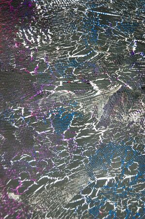 Craquelured black blue and purple color paper texture close-up