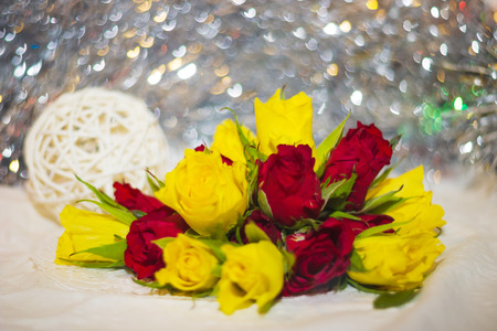 red and yellow small roses buds with bokeh and ball of twigs on the background shallow depth of fieldの写真素材
