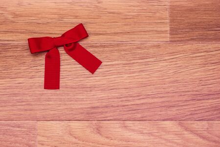 Red bow toned picture on background with wooden surface imitationの写真素材