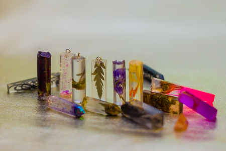 Flowers and glitters inside of crystals made of epoxy resin close-up with bokeh on toned background...