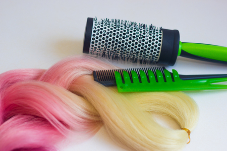 Blonde and pink colored kanekalon material for Afro-braids and other hairstyles close-up shallow depth of field and combs in the backgroundの写真素材