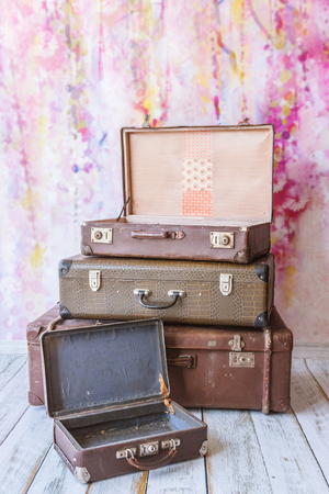 pyramid of several vintage suitcases on a pink background toned picture close-up shallow depth of fieldの写真素材