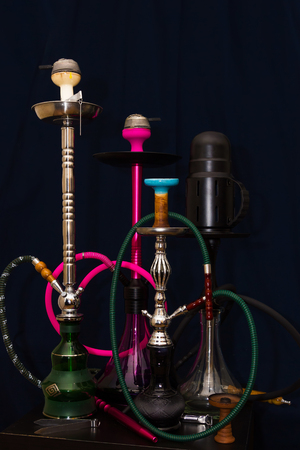 four different hookahs on the table on a dark blue background shot in low key style toned imageの写真素材