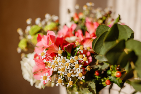 lush bouquet with berries and daisies in sunlight close-up shallow depth of fieldの写真素材