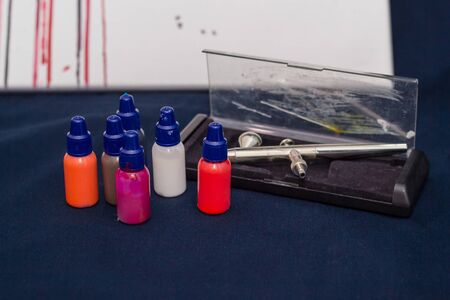 Airbrush tool and paints still life on dark background. Close-up, shallow depth of fieldの写真素材