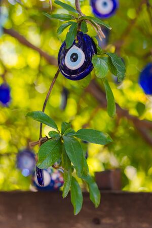 Multicolored nazar - evil eye amulets in store on the street. Close-up, shallow depth of field. Picture with bokeh and Sun rayの写真素材
