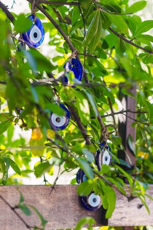 Multicolored nazar - evil eye amulets in store on the street. Close-up, shallow depth of field. Picture with bokeh and Sun rayの写真素材