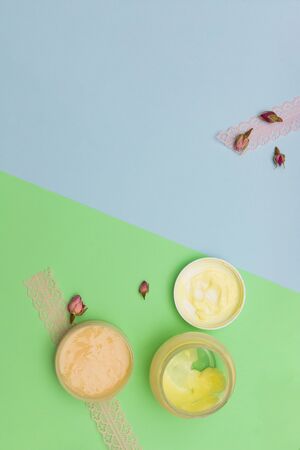 Cosmetic creams flat lay on colored background. Place for textの写真素材