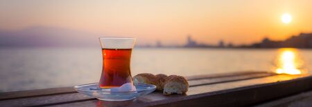 tea in traditional turkish glass and turkish bagel simit at dawn against the backdrop of the gulf of...