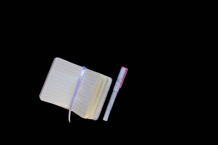 Open notebook and pen with trendy marble pattern lie on black background flat lay. Picture with...