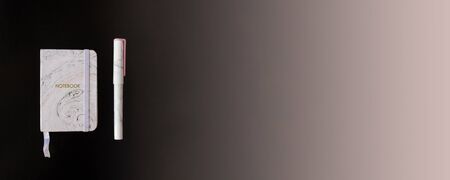 Notebook and pen with trendy marble pattern lie on black background flat lay. Picture with copy space. Bannerの写真素材