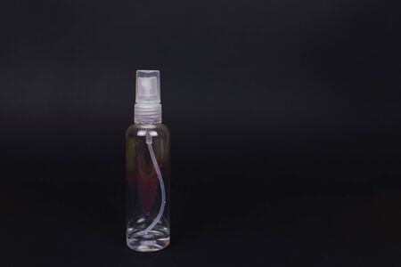 Transparent bottle with antiseptic residues. Lack of household antiseptics in stores. Crisis due to coronavirus COVID-19 quarantine. Picture with black background and copy spaceの写真素材