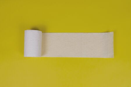 Roll of toilet paper on yellow background. Toilet paper crisis due to coronavirus COVID-19...