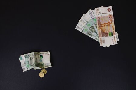 Smooth and wrinkled banknotes Russian Rubles top view on black background. Optimistic forecast for...