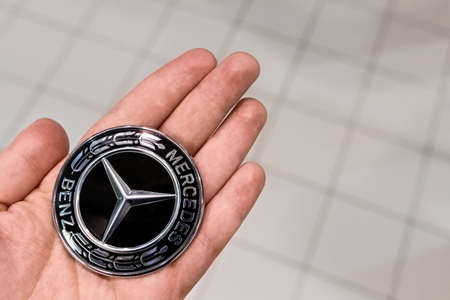 SAINT-PETERSBURG, RUSSIA, MARCH 1 2020: Mercedes logo banner on the palm. Close-up shallow depth of...