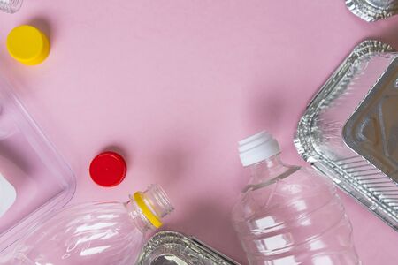 Bottles and containers flat lay on pink background with copy space. Stop plastic concept. Plastic and aluminum waste. Recycling garbage. Say no to plastic. Garbage sorting. Ecological pollution.の写真素材