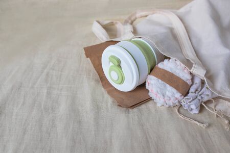 Eco-friendly shopping. Shopper bag with collapsible silicone mug, mesh bag and reusable cotton discs set for face or makeup removal tied with twine. Zero waste conceptの写真素材