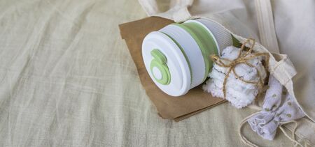 Eco-friendly shopping. Shopper bag with collapsible silicone mug, mesh bag and reusable cotton discs set for face or makeup removal tied with twine. Zero waste concept bannerの写真素材