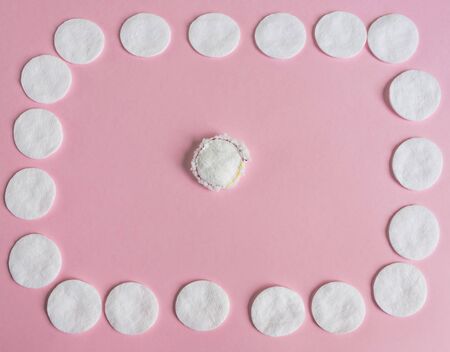 One reusable and many disposable cotton discs for face or makeup removal flat lay. Eco-friendly lifestyle, zero waste concept.の写真素材