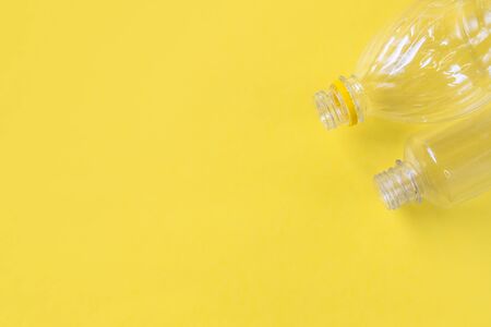 Plastic bottles top view on yellow background with copy space. Stop plastic concept. Say no to plastic. Garbage sorting. Recycling garbage. Single-use plastic objects. Ecological pollution.の写真素材