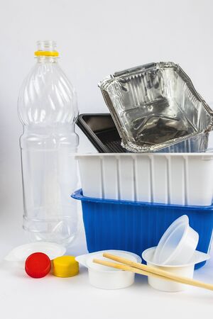 Plastic waste bottles and containers, chopsticks and aluminum container. Recycling garbage on white background Stop plastic concept. Garbage sorting. Single-use plastic objects. Ecological pollution.の写真素材