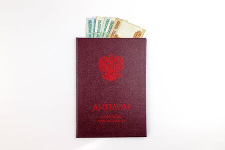 Russian Diploma of higher education and inside Russian rubles banknotes. Bribe to obtain an education certificate concept.の写真素材