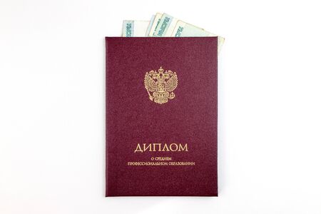Russian Diploma of secondary education and inside Russian rubles banknotes. Bribe to obtain an education certificate concept.の写真素材