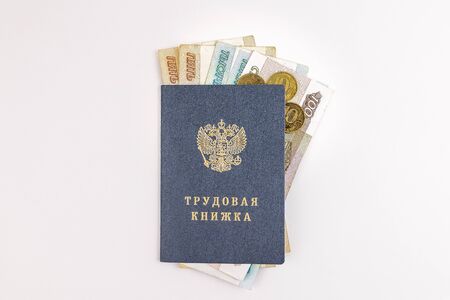 Employment history. On the cover text in Russian Labor book. Inside are Russian rubles banknotes. Twelve thousand one hundred and thirty rubles â amount of unemployment benefit in Russia in 2020.の写真素材