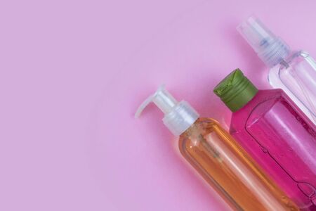 Skin care cosmetics. Facial and body wash gel and spray on pink background with copy space....