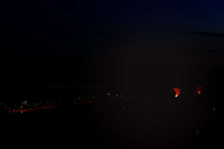 Goreme, Cappadocia, Turkey â 23 August 2019: Many hot air balloons blast off in sky at dawn. People look at them from the ground. Cappadocia Earth Pyramids. Tourism concept.のeditorial素材
