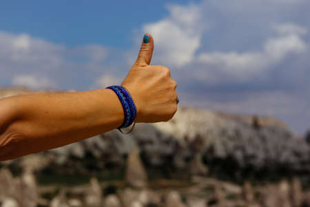 Thumbs up of women hand with Cappadocia, Turkey on background. Picture with shallow depth of fieldの写真素材