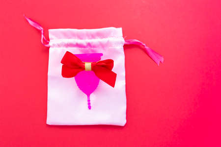 Menstrual cup as a gift, flat lay on pink background. Zero waste concept. Caring for the environment. Women Health. Picture with place for textの写真素材