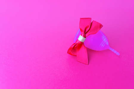 Menstrual cup as a gift, flat lay on pink background. Zero waste concept. Caring for the environment. Women Health. Picture with place for textの写真素材