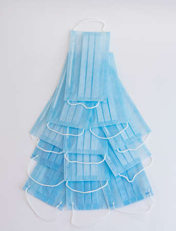 Christmas tree made of disposable medical masks isolated on white. The concept of celebrating the New Year in the context of the covid-19 pandemicの写真素材