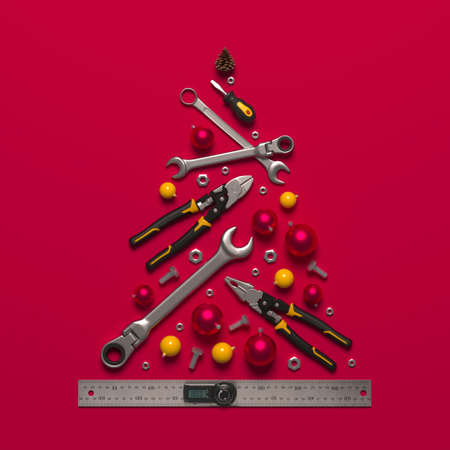 A symbolic Christmas tree made of construction tools on a blue background. Creative template of a New Year greeting for building and engineering companies. 3D render.の写真素材