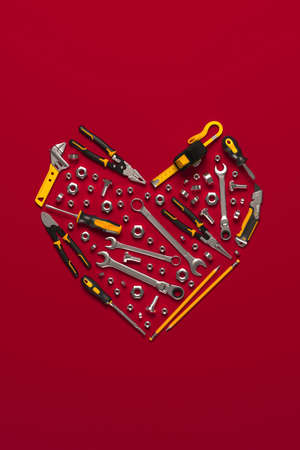 A symbolic heart made of construction tools set. Creative template for the Builder's Day, Labor Day (and similar professional holidays) or the Valentine's Day greeting card or banner. 3D rendering.の写真素材