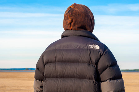 Moscow, Russia - March 9, 2022: A man from the back in a black jacket by The North Face. close-up logo.のeditorial素材