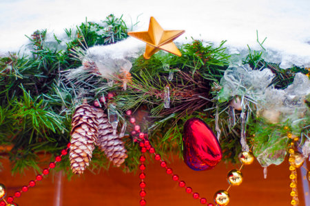 Happy Holiday concept. Festive decorations, Christmas evergreen branches, cones, balls on the street. Festive decoration of the house outside in winter.の写真素材