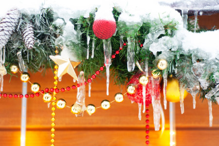 Festively decorated facade of the building of the house, on the street in winter, on a blurred background. Christmas lantern, balls, branches, lights. New Year holidays, background, winter season.の写真素材