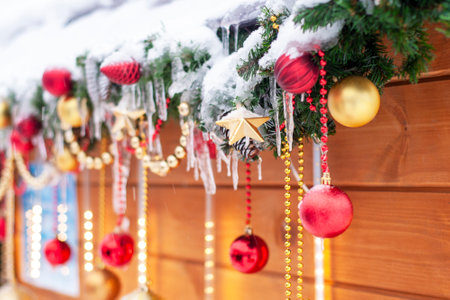 Happy Holiday concept. Festive decorations, Christmas evergreen branches, cones, balls on the street. Festive decoration of the house outside in winter.の写真素材